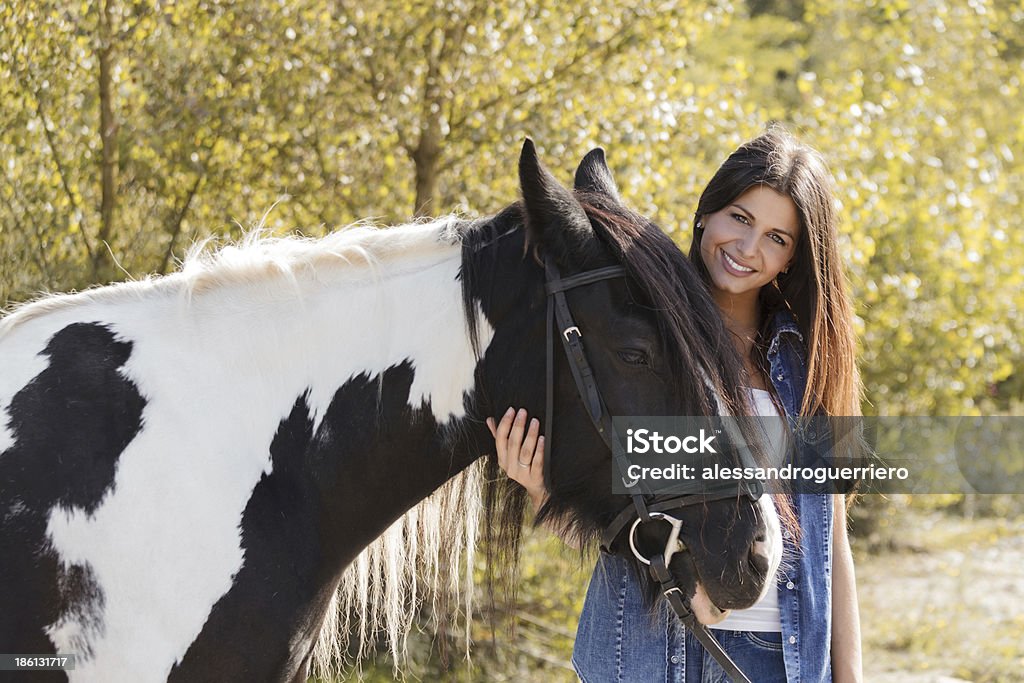 Hermosa joven rider que enaltece su caballo - Foto de stock de Abrazar libre de derechos