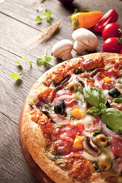 istock Delicious fresh pizza served on wooden table 186132324
