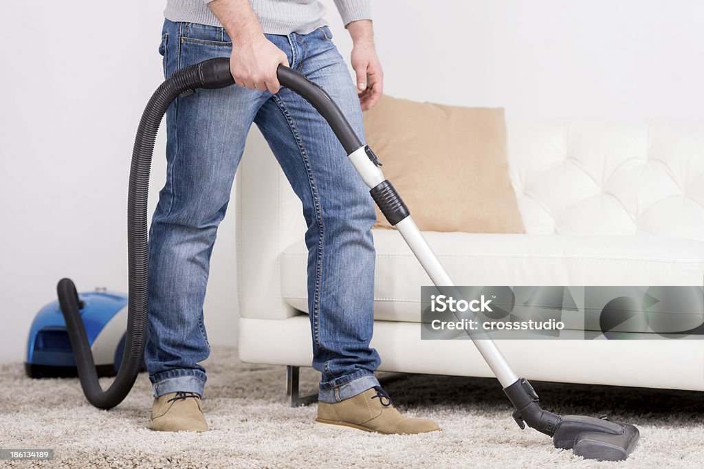 Vacuum Cleaner. A man does house work with a vacuum cleaner Activity Stock Photo