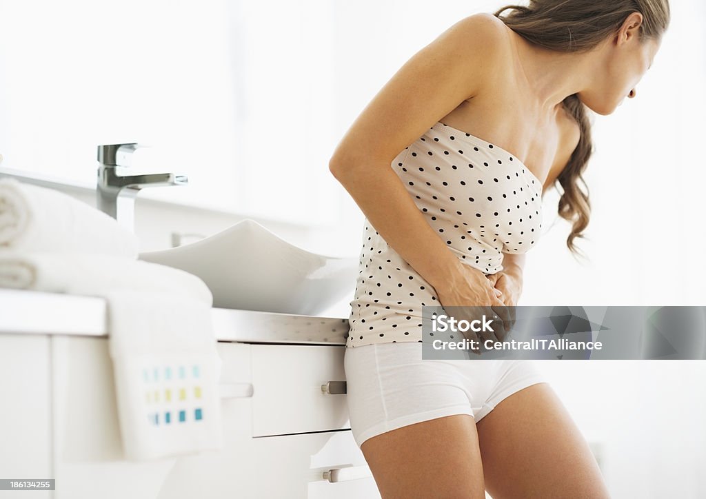 Woman having stomachache in bathroom Abdomen Stock Photo