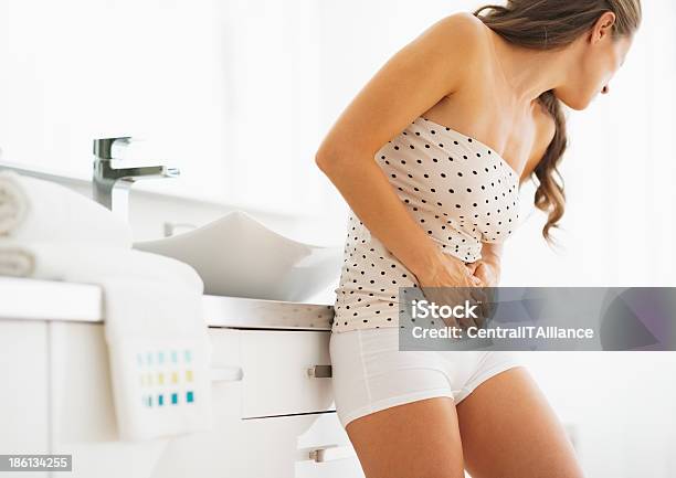 Woman Having Stomachache In Bathroom Stock Photo - Download Image Now - Abdomen, Adult, Bathroom