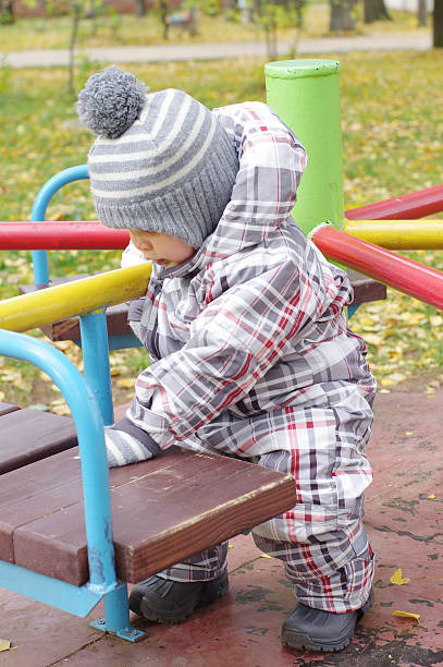 istock baby plays outdoors in autumn on playground 186135839