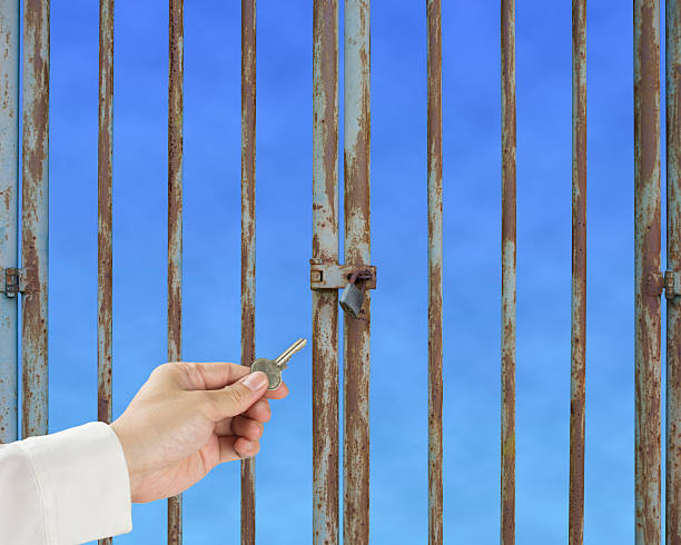 istock Hand hold key unlocking locked door with blue sky background 186136857