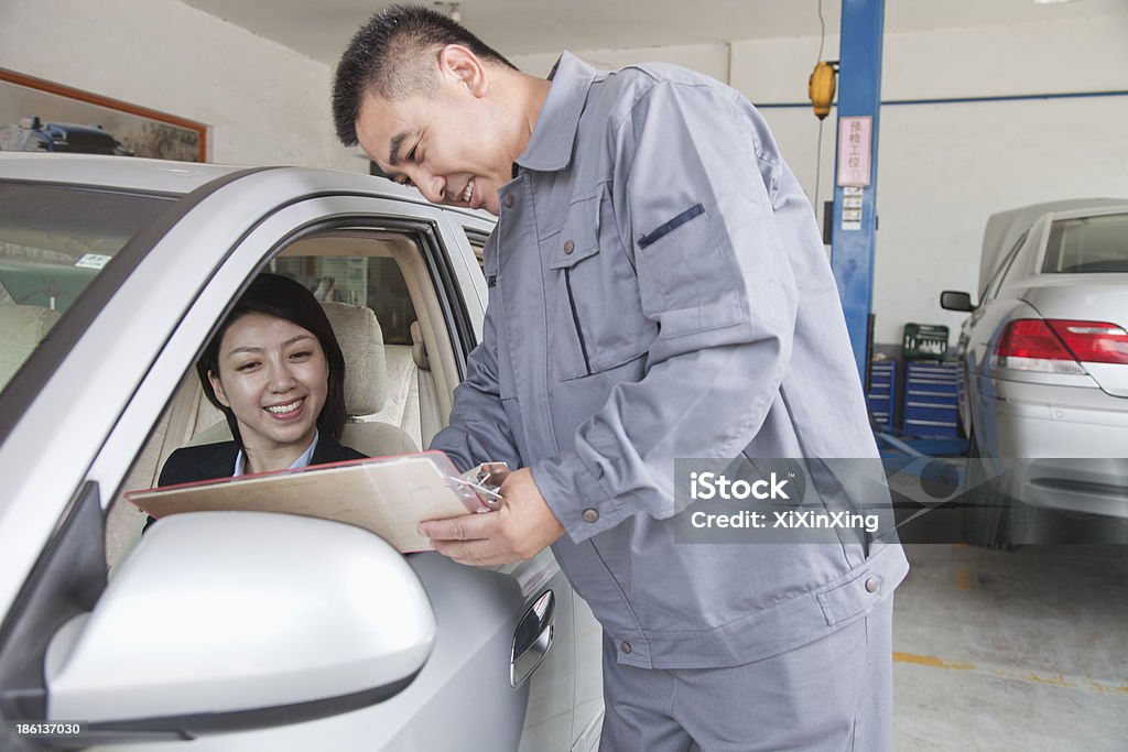 Mecánico explicar a empresaria - Foto de stock de Coche libre de derechos