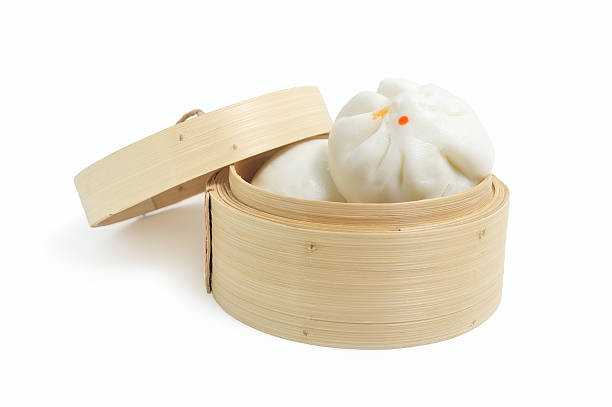 Chinese steamed buns in bamboo basket isolated on white background stock photo