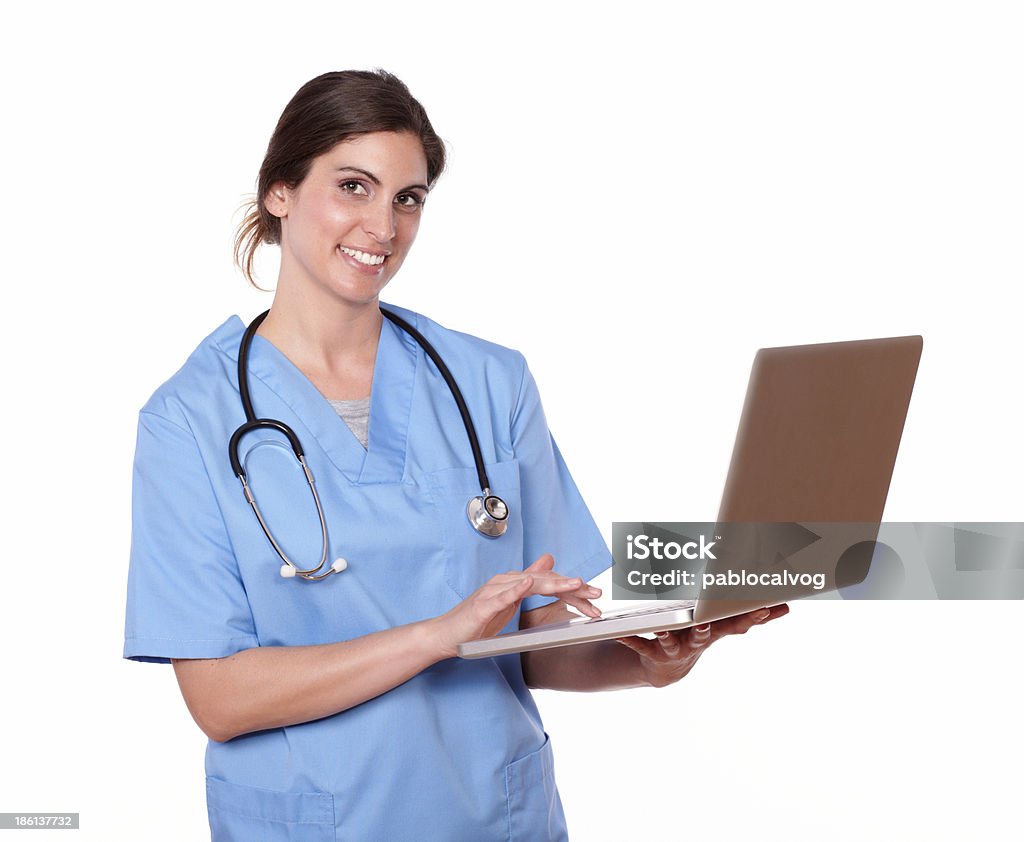 Dość pielęgniarki uśmiechając się podczas korzystania z jej laptop - Zbiór zdjęć royalty-free (Biały)