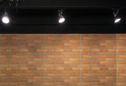 Red brick wall with light from spotlight and empty wall copy space for text. Announcement board concept.