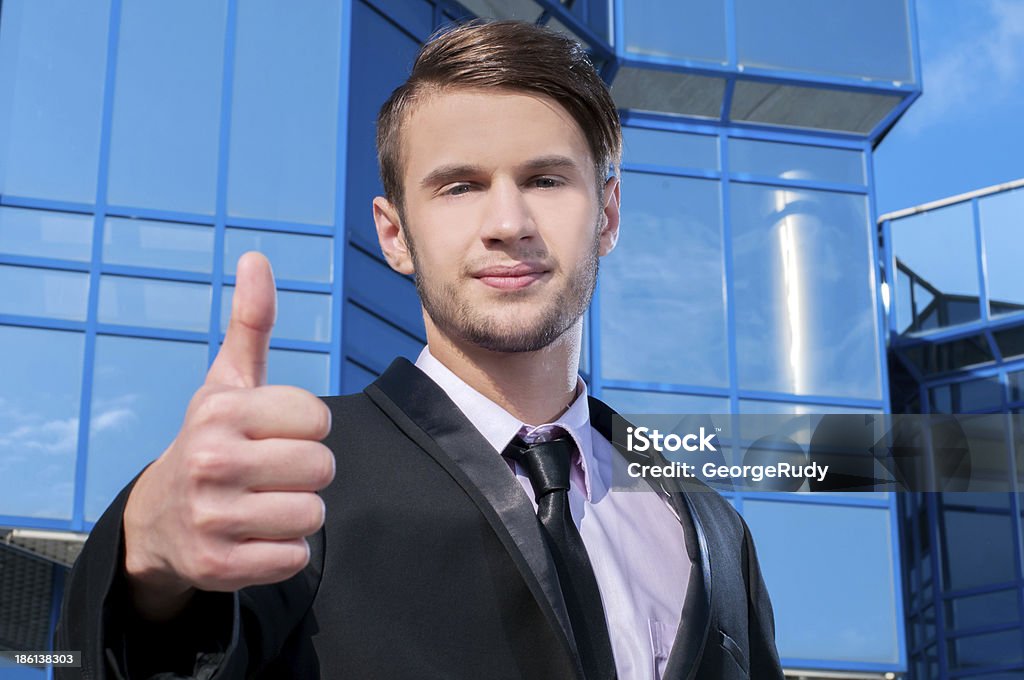 Businessman Portrait of a young businessman with thumb up at office building Adult Stock Photo
