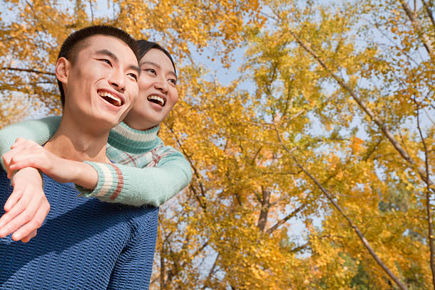istock Young couple piggyback in park 186138344