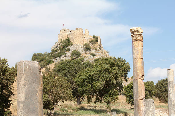 Stone tower of Kapetanakis in Messinia, Greece, showcasing traditional Maniot architecture amidst scenic Mediterranean vegetation and hills.
