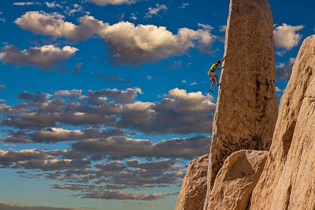 istock One climber struggling up a dangerous cliff 186139814