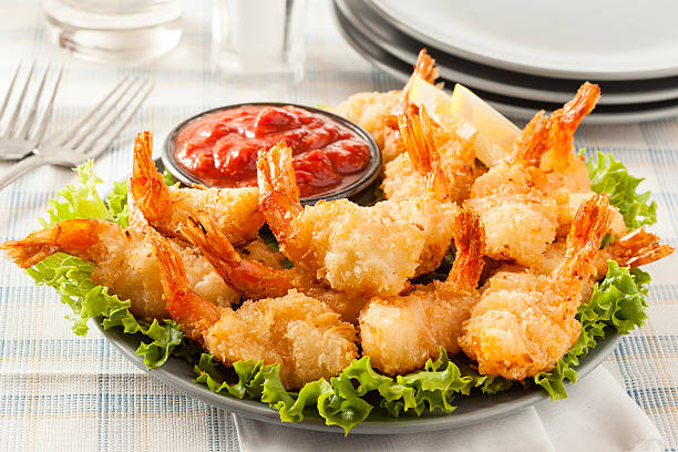Fried Organic Coconut Shrimp Fried Organic Coconut Shrimp with Cocktail Sauce breaded photos stock pictures, royalty-free photos & images