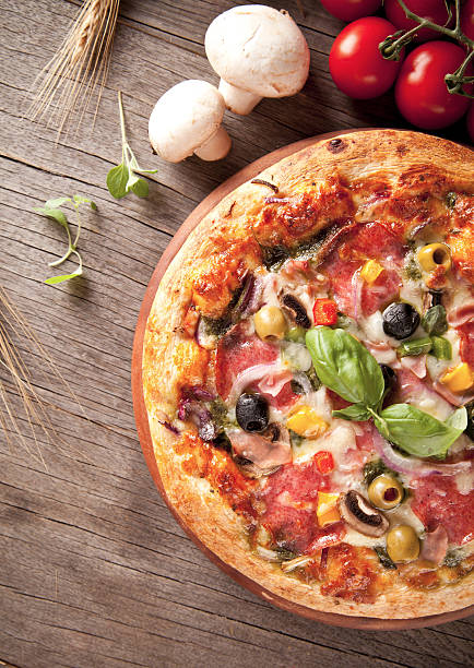 istock Delicious fresh pizza served on wooden table 186142124