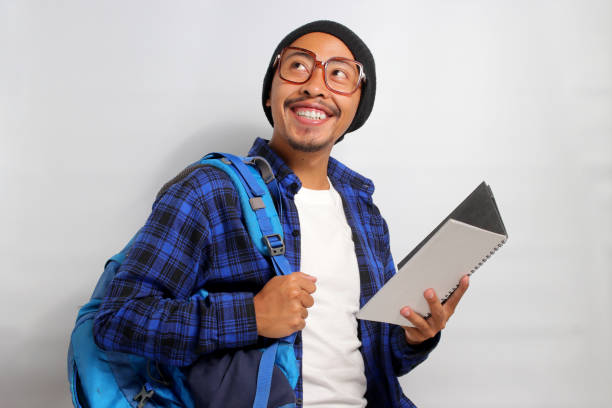 istock Happy young Asian student looks excited while holding a book 1861430734