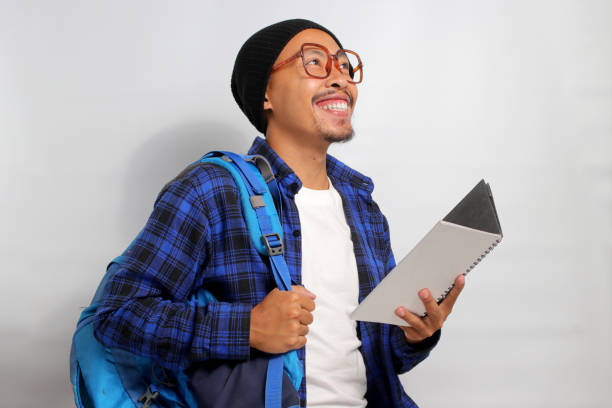 istock Happy young Asian student looks excited while holding a book 1861432306