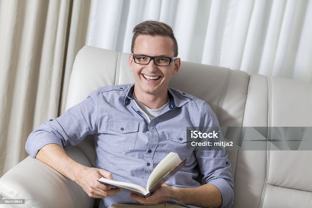 Young cute man reading a book Young cute man reading a book at home Adult Stock Photo