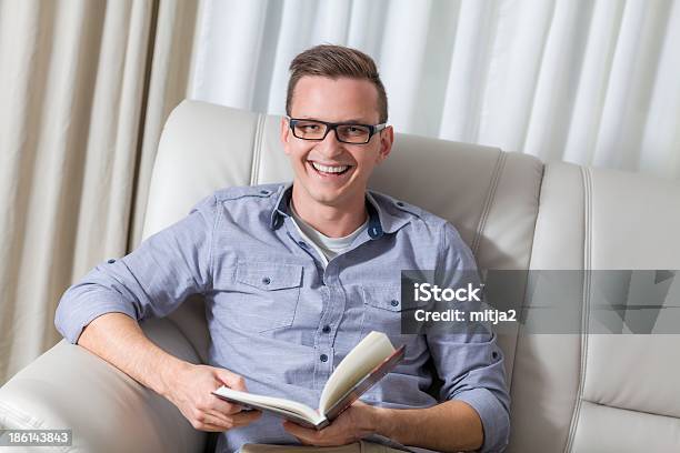 Young Cute Man Reading A Book Stock Photo - Download Image Now - Adult, Adults Only, Apartment