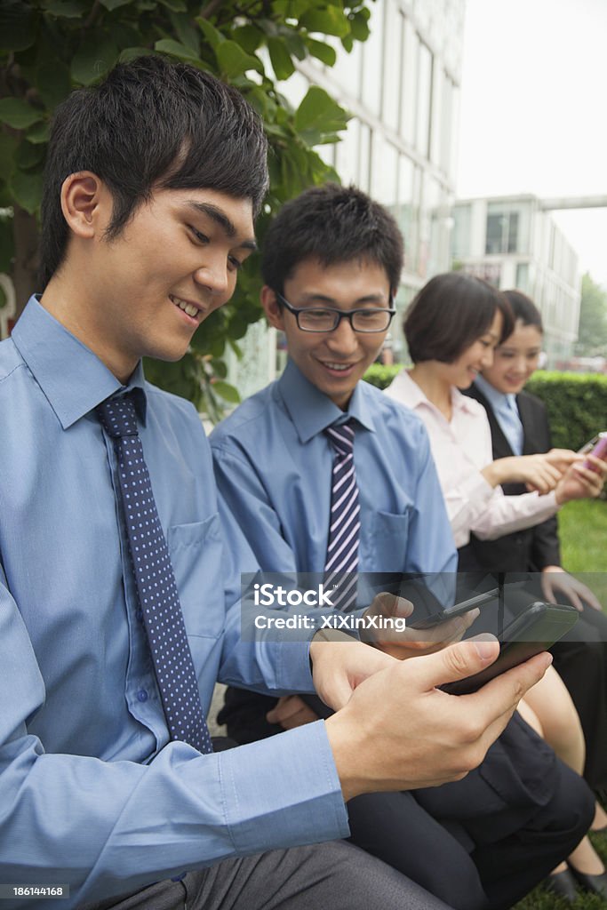 Young business people checking their cell phones 20-24 Years Stock Photo