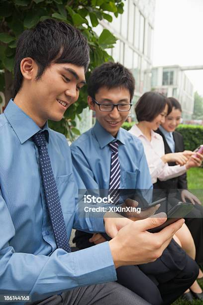 Young Business People Checking Their Cell Phones Stock Photo - Download Image Now - 20-24 Years, Adult, Adults Only