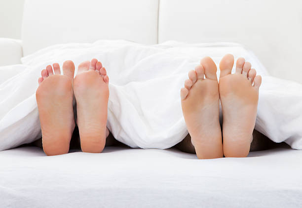 istock Close-up of couple's feet sleeping on bed 186145860