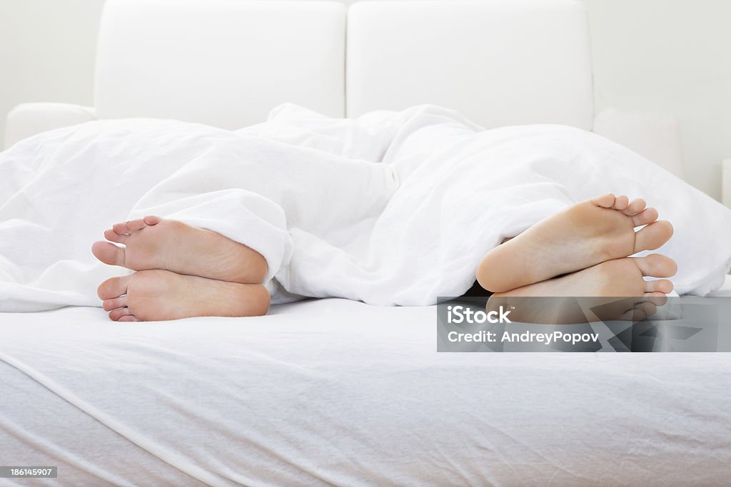 Primer plano de la pareja cuadrados de dormir en la cama - Foto de stock de Blanco - Color libre de derechos