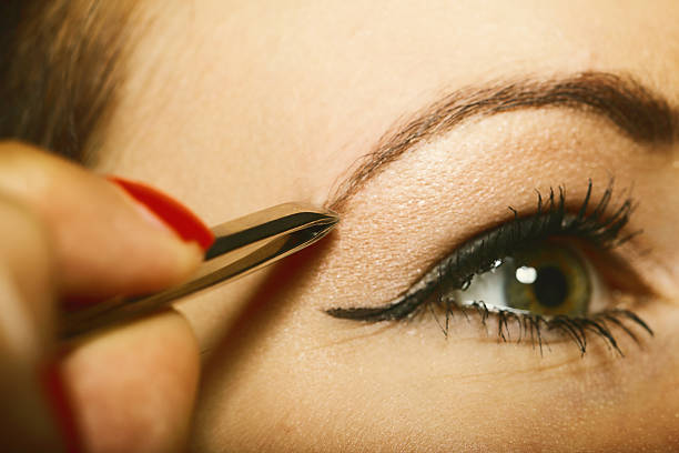 istock part of face woman plucking eyebrows 186145909