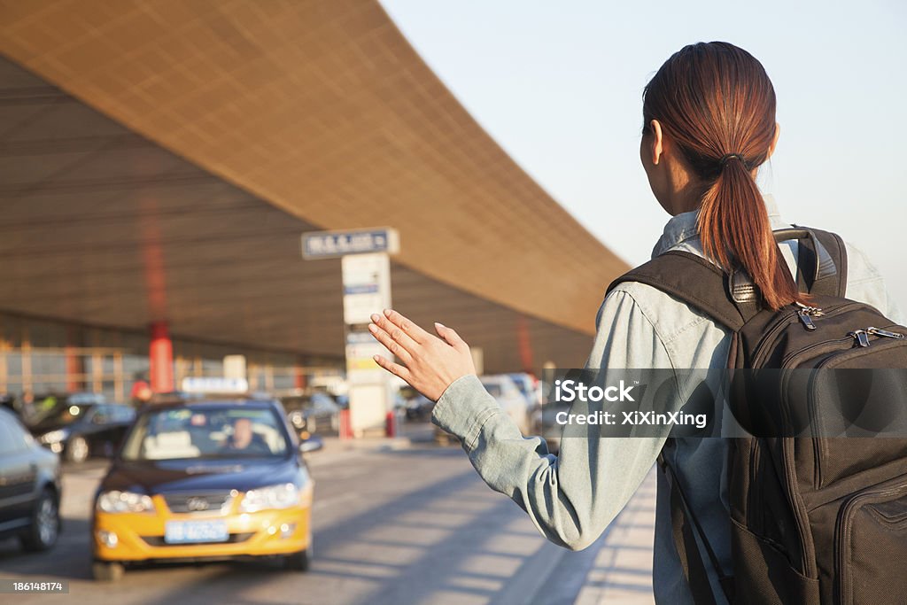 Joven que llamar un taxi en el aeropuerto - Foto de stock de Llamar - Gesticular libre de derechos