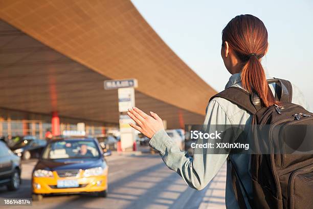 Jovem Viajante Chamar Um Táxi De Aeroporto - Fotografias de stock e mais imagens de Chamar - Gesticular - Chamar - Gesticular, Só Uma Mulher, 30-34 Anos