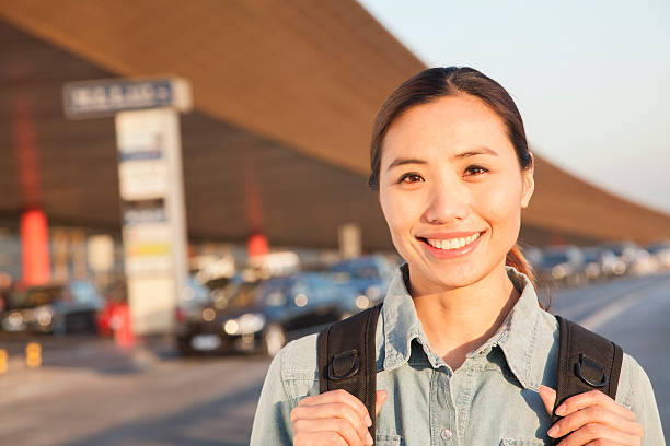viaggiatore giovane ritratto di fuori dell'aeroporto - ponytail brown hair tourist women foto e immagini stock