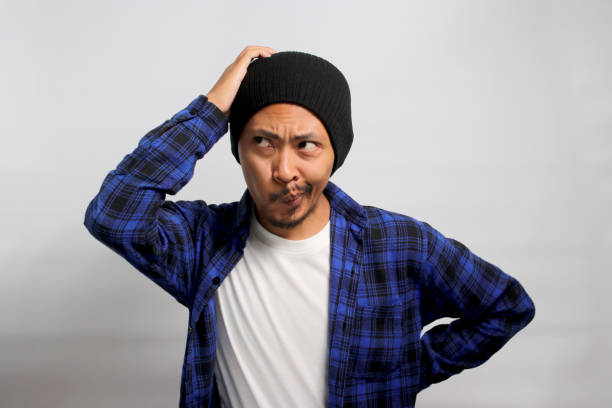 istock Puzzled young Asian man is scratching his head while contemplating 1861482286