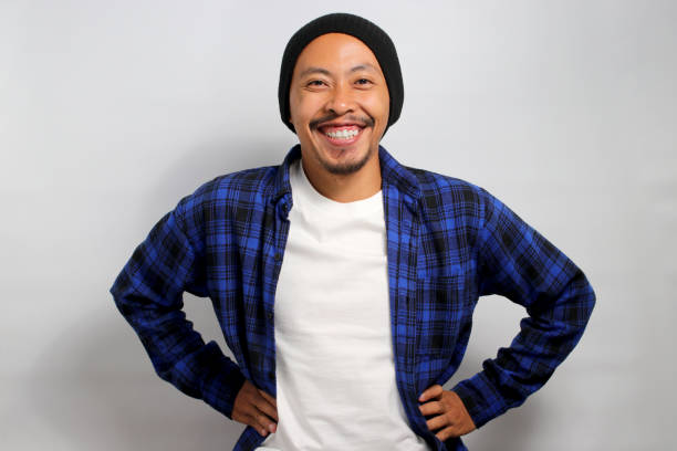 istock Optimistic young Asian man is standing with his arms akimbo 1861485434