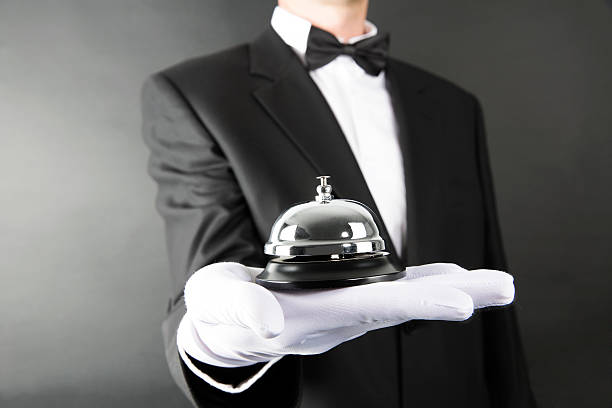 Bell Serving Butler serving a bell in his palm. domestic staff stock pictures, royalty-free photos & images
