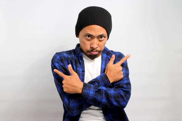 istock Asian man is pursing his lower lip and pointing in a different direction 1861596052