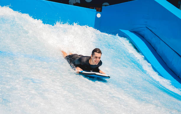 istock Young man surfing on a wave simulator at a water amusement park 1861635845