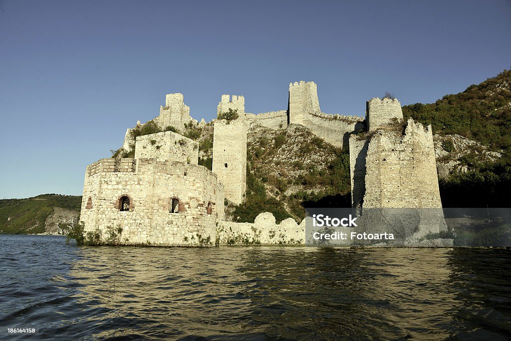 Golubac Fortress on Danube, Serbia Old ruined Golubac fortress at the entrance to the Danube Iron Gate, four kilometers downstream from Golubac town in Serbia. It was first mentioned in 1335. The nine massive towers are connected by a wall with walkways. Ancient Stock Photo