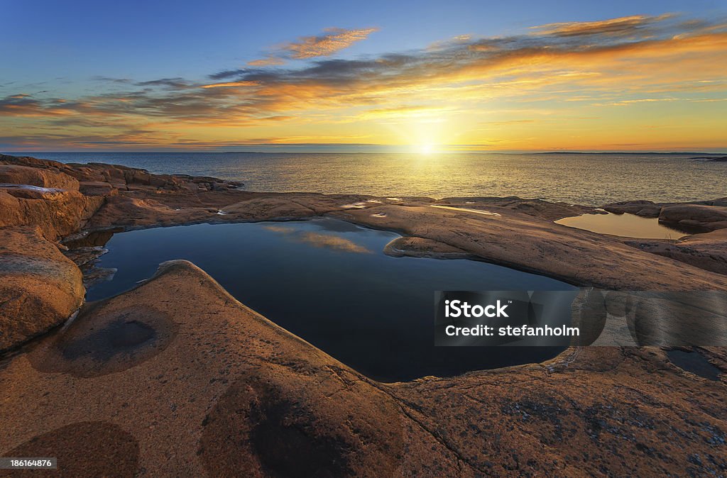 Sunrise over sea during summer Beautiful sunrise over sea at Geta during summer, Åland, Finland Navy Blue Stock Photo