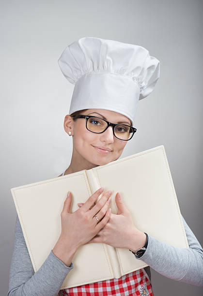 istock Pretty female chef with a cookbook 186164922