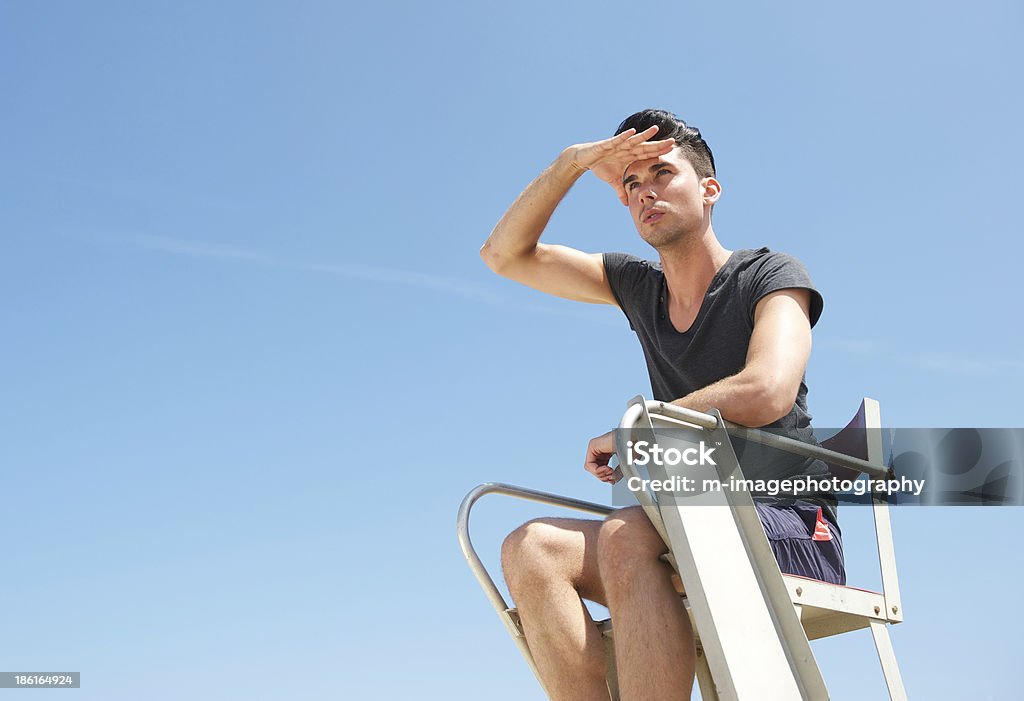 Portrait d'un maître-nageur, assis sur une chaise sur la journée d'été - Photo de Hommes libre de droits
