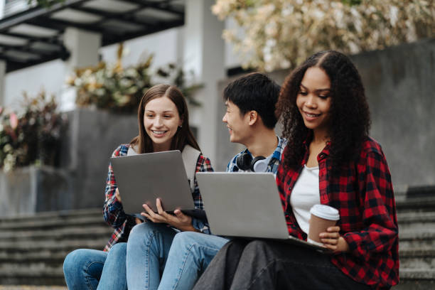 istock college student reading a book study on laptop prepare for the exam Or work on a group project while sitting on the steps of the university. 1861666765