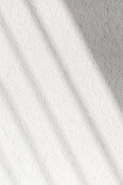 istock Textured white wall with organic drop diagonal shadow of window 1861683879
