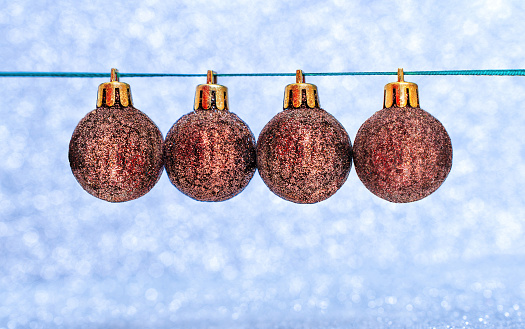 Miniature Christmas balls on a string, set against a sparkling background, with a designated space for the inscription of the year.