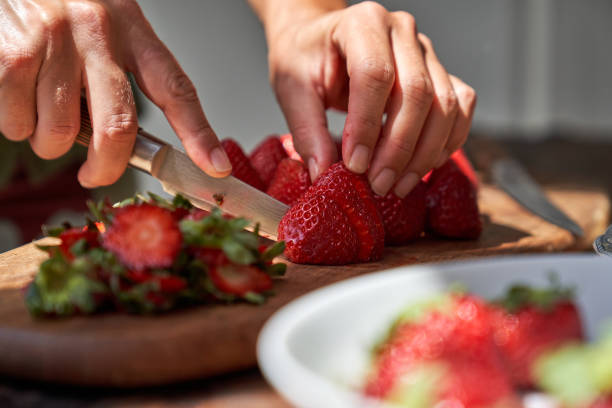 istock Crop cook cutting strawberry with knife 1861722245