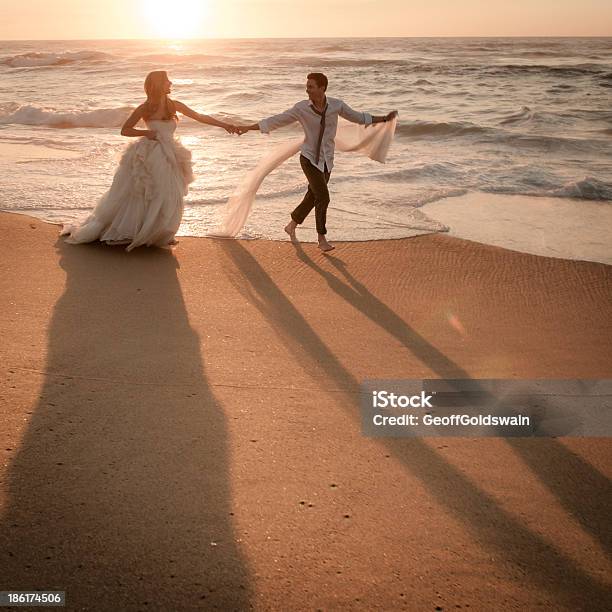 Joven Pareja Bailando En La Playa Al Amanecer En La Playa Foto de stock y más banco de imágenes de Adulto