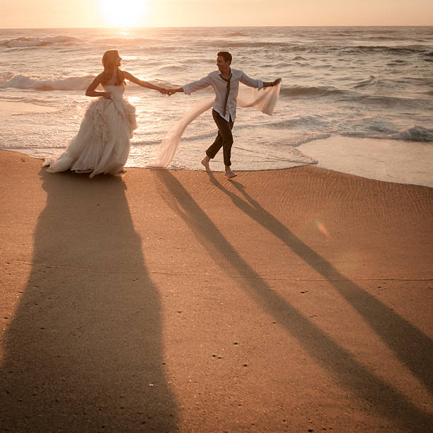 istock Young couple dancing along the sand at sunrise on beach 186174506