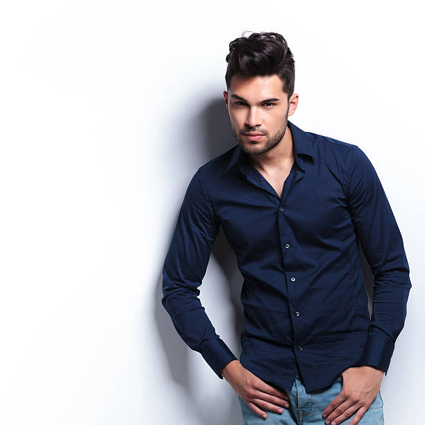 istock young man looks at you with thumbs in pockets 186176903