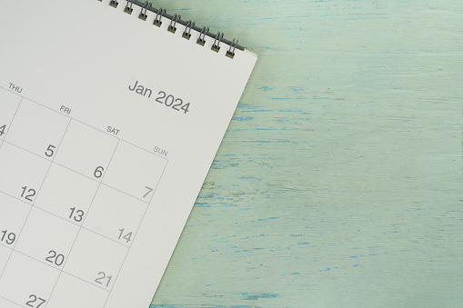 close up of January 2024 calendar on the blue table background, planning for business meeting or travel planning concept