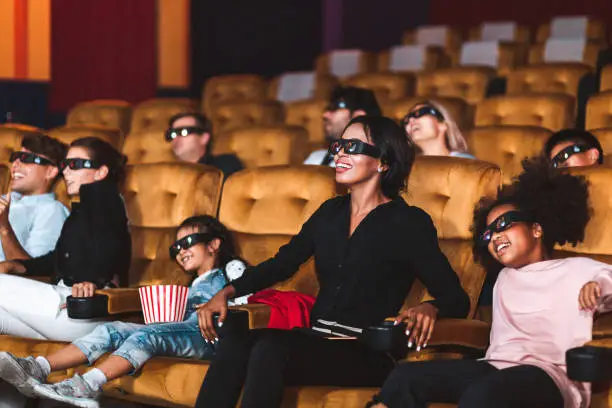 Happy and fun group of people watch 3D cinema with 3D glass in movie theater