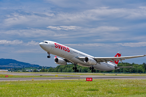 Swiss airplane Airbus A330-343 registration HB-JHN taking off from Zürich Kloten Airport on a sunny summer day. Photo taken July 23rd, 2023, Zurich, Switzerland.