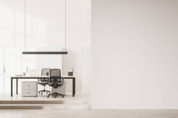 istock Light business interior with table and laptop computer, shelf and mock up wall 1861806348