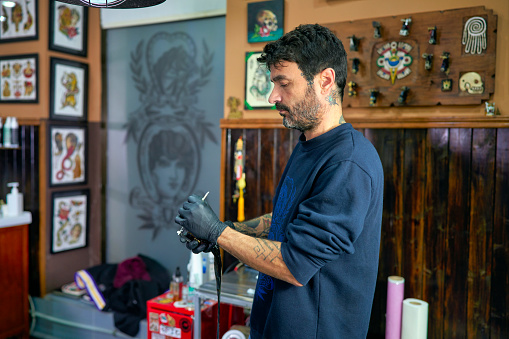 Tattoo artist preparing the needle for his tattoo machine